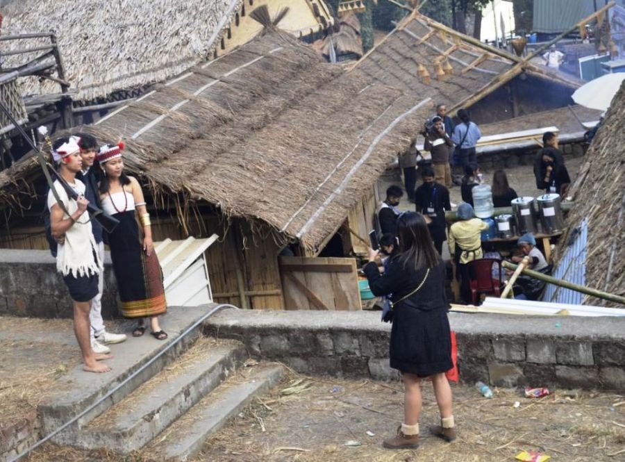 A tourist click pictures with young people dressed in their traditional attire on day two of the 23rd Hornbill Festival at the Naga Heritage Village, Kisama on December 2, 2022. (Morung File Photo)